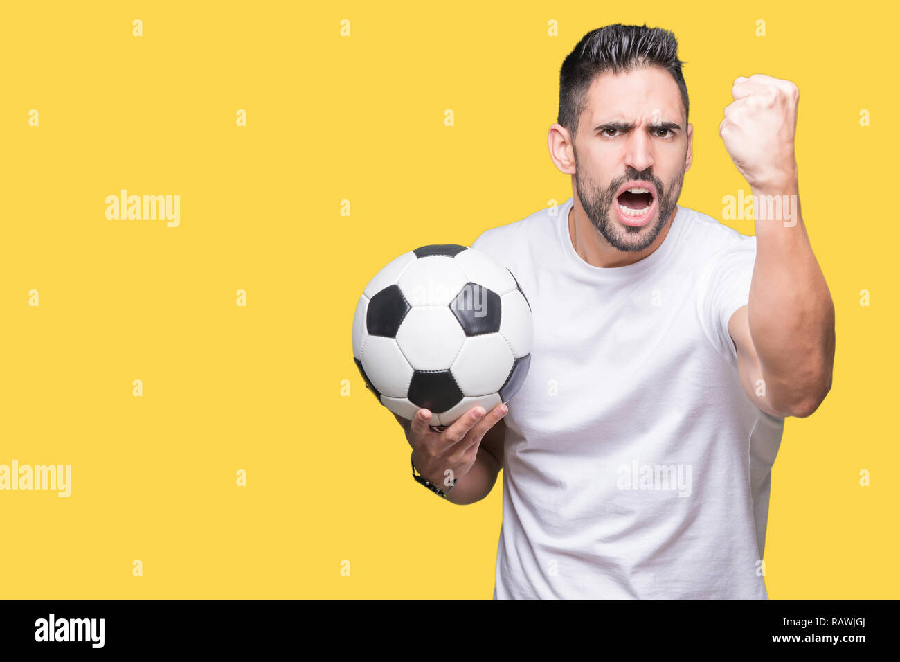 Young man holding soccer football ball over isolated background annoyed ...