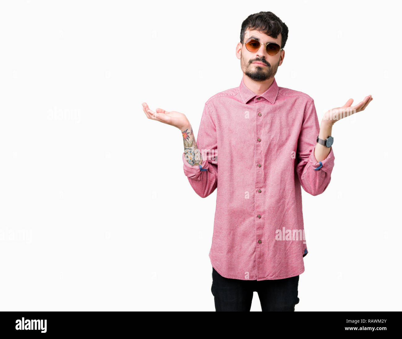 Young handsome man wearing sunglasses over isolated background clueless and confused expression with arms and hands raised. Doubt concept. Stock Photo