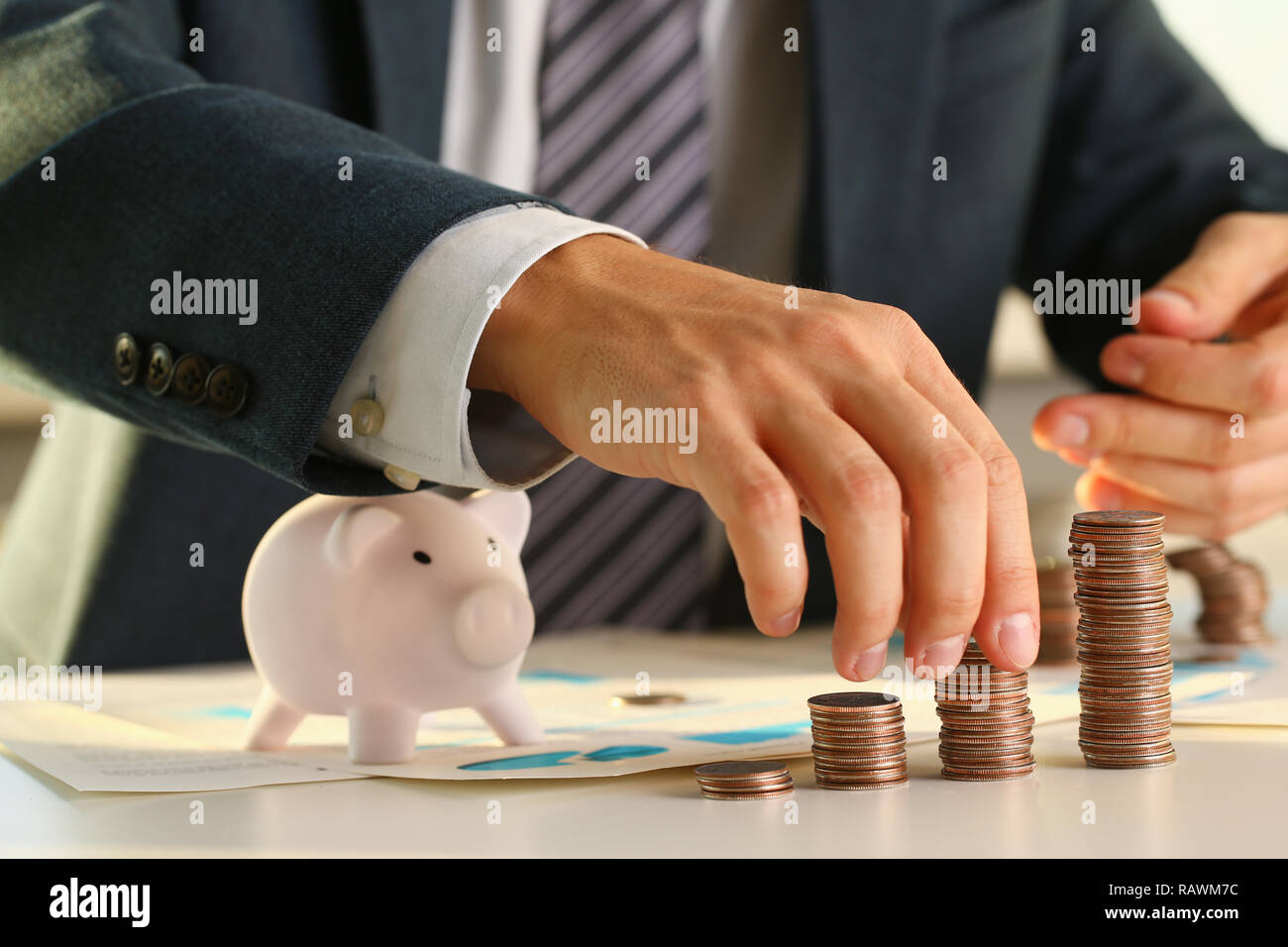 Hand businessman putting pin money into pig Stock Photo Alamy