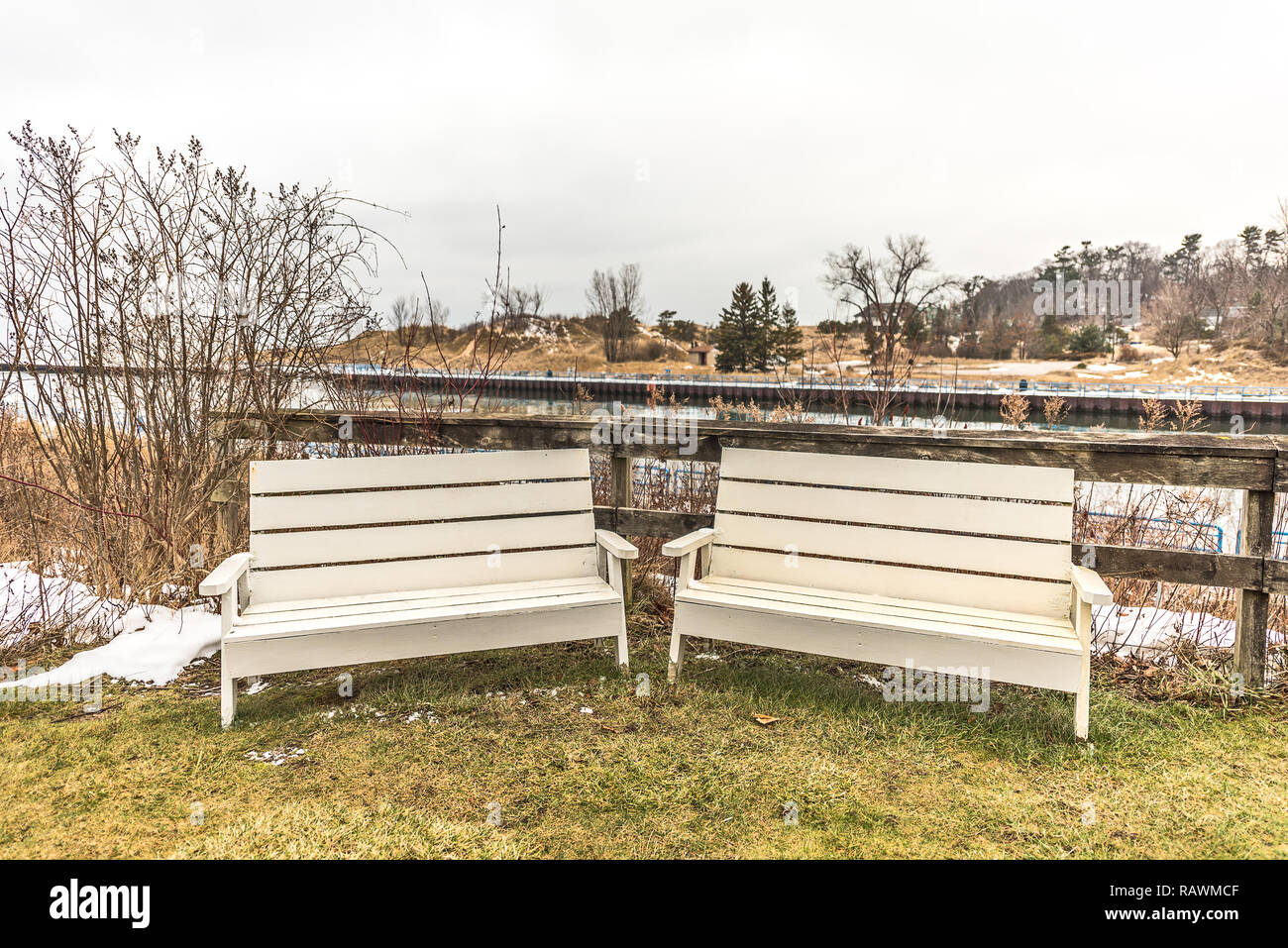 Two cream-colored benches waiting for someone to sit down and visit with the White River behind them. Stock Photo