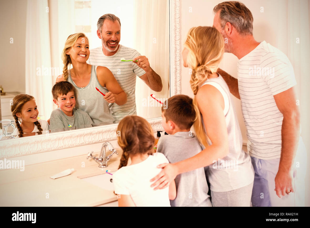 Parents and kids brushing teeth in bathroom Stock Photo