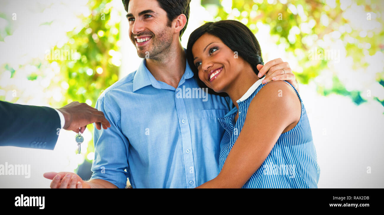 Real estate agent giving house keys to couple Stock Photo - Alamy