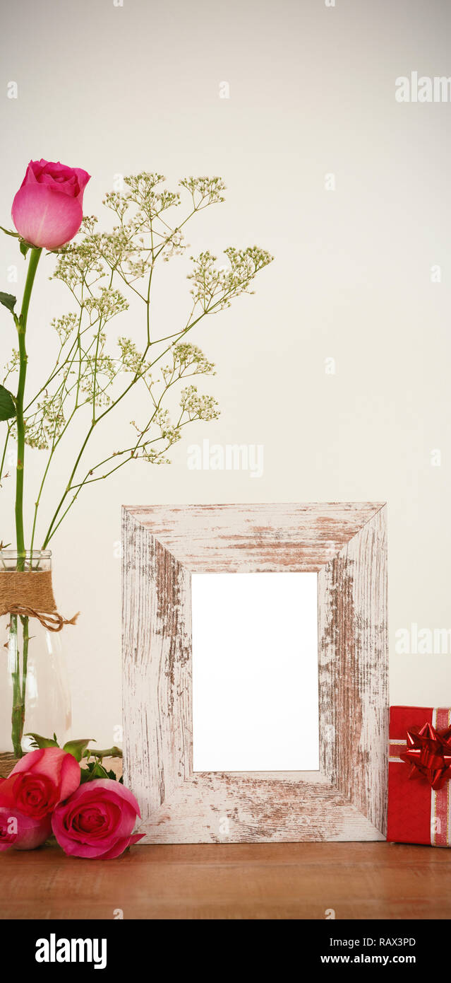 Rose flower in glass vase, photo frame and gift box Stock Photo - Alamy