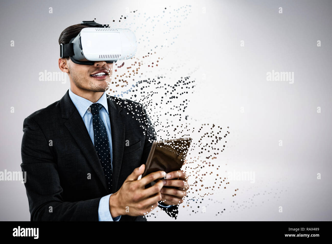 Composite image of businessman wearing vr glasses while using tablet Stock Photo