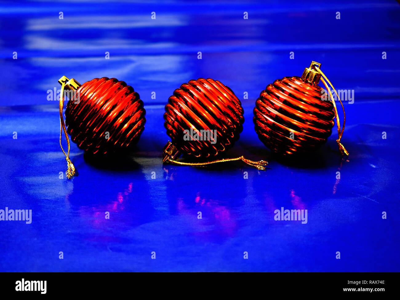 Three red Christmas balls on blue background. Stock Photo