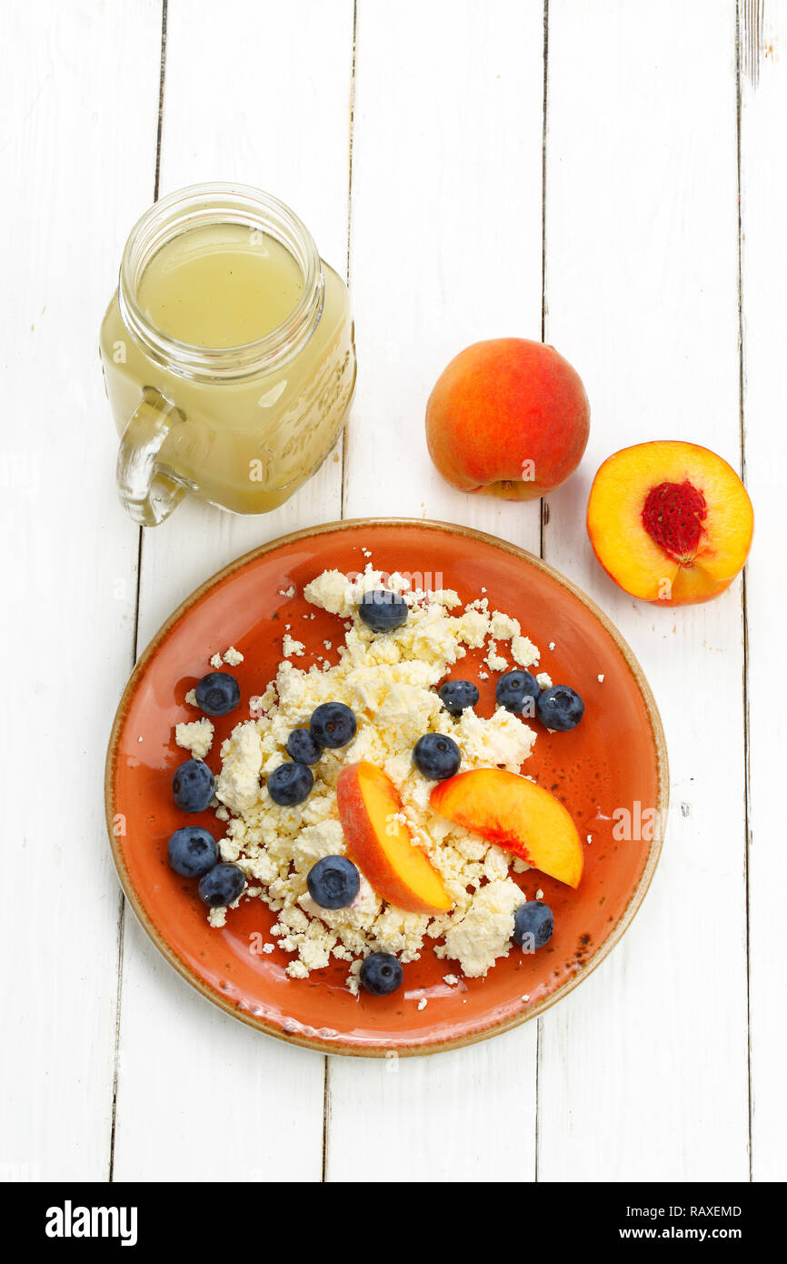 Still life with cottage cheese, smoothie, blueberry and peach on a