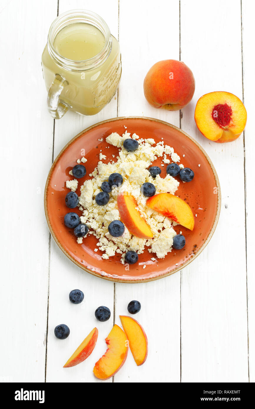 Still life with cottage cheese, smoothie, blueberry and peach on a