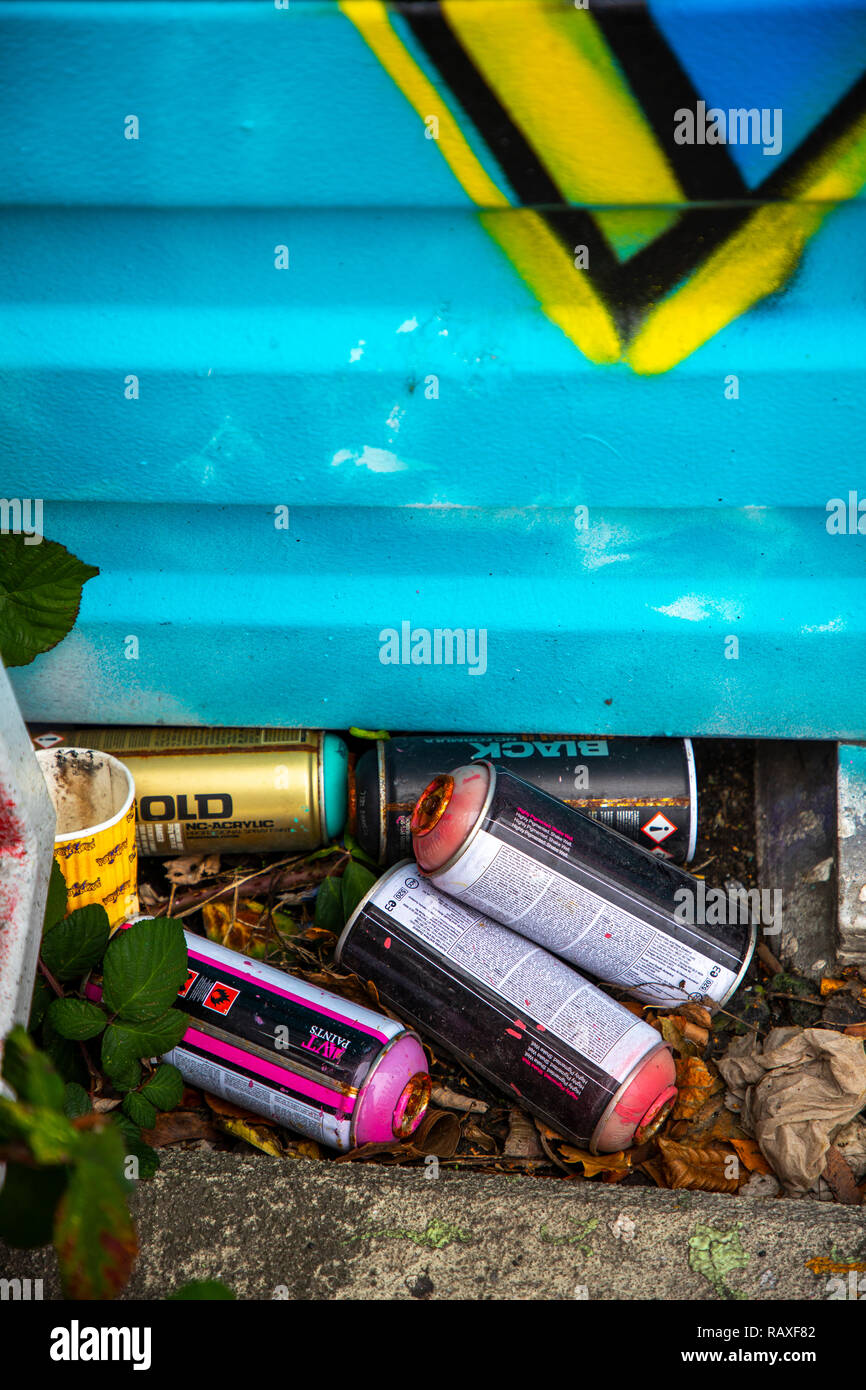 Used, empty, paint spray cans, on a noise barrier on the A40 motorway