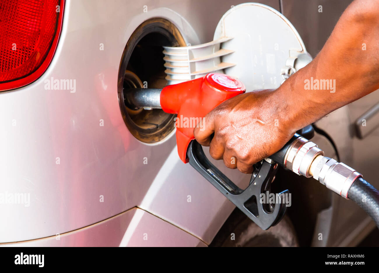 Detail hand of worker man refuelling car at the petrol station. Concept photo for use of fossil fuels (gasoline, diesel) in combustion engines, air po Stock Photo