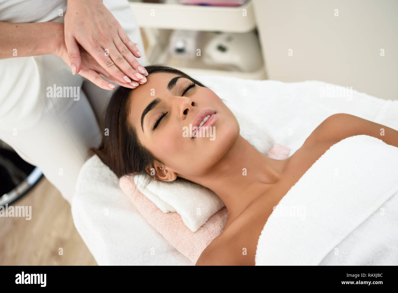 Arab woman receiving head massage in spa wellness center. Beauty and Aesthetic concepts. Stock Photo