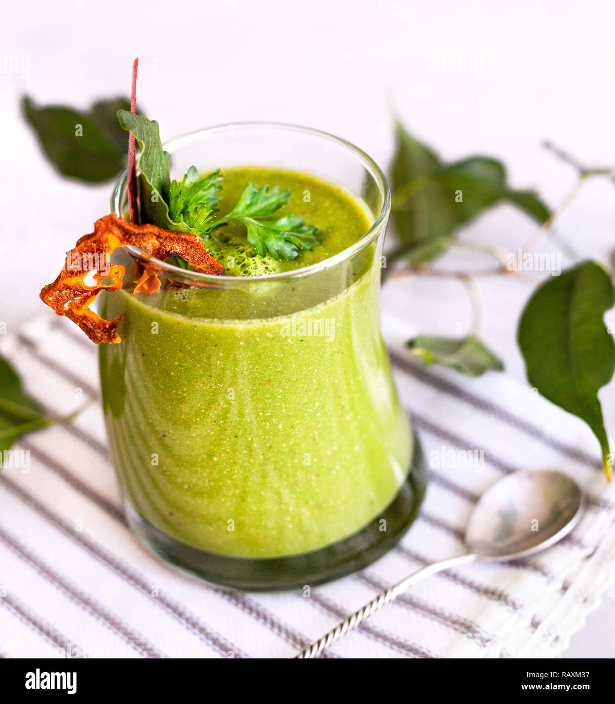 Green smoothie decorated with parsley and dry fruit close up in restaurant Stock Photo