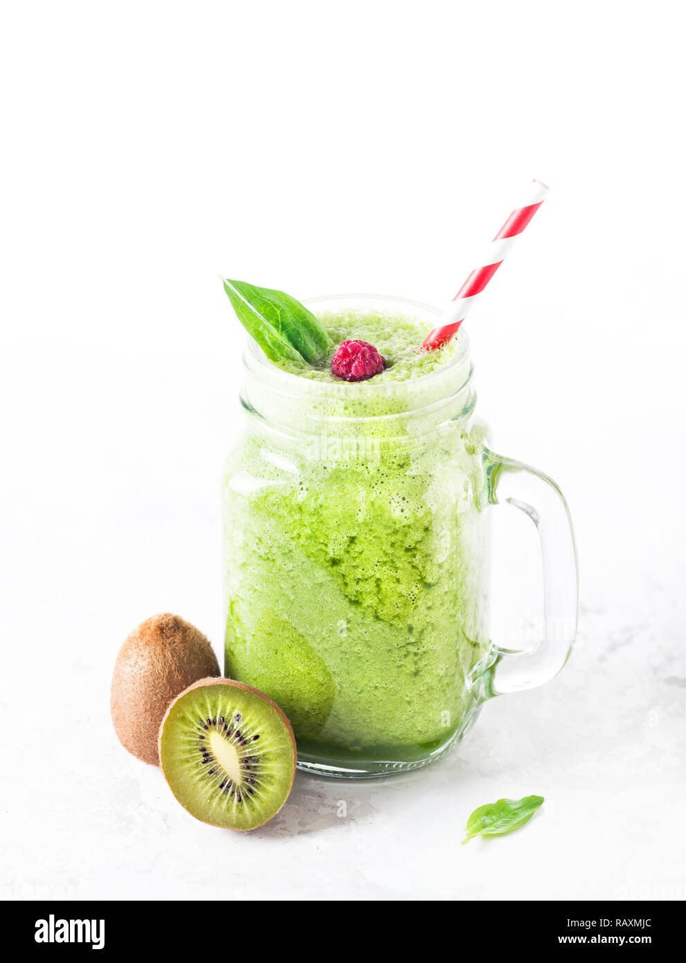 Green smoothie with kiwi, green apple and spinach, decorated by berry on white background Stock Photo