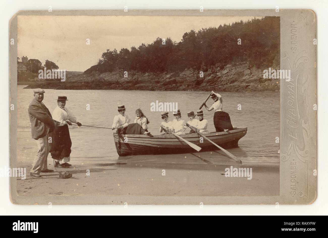 Early Edwardian cabinet card of 7 young ladies and girls wearing long skirts and straw boaters enjoying themselves and landing a rowing boat at Mill Bay, Salcombe, Devon, U.K.  Summer June 1901 Stock Photo