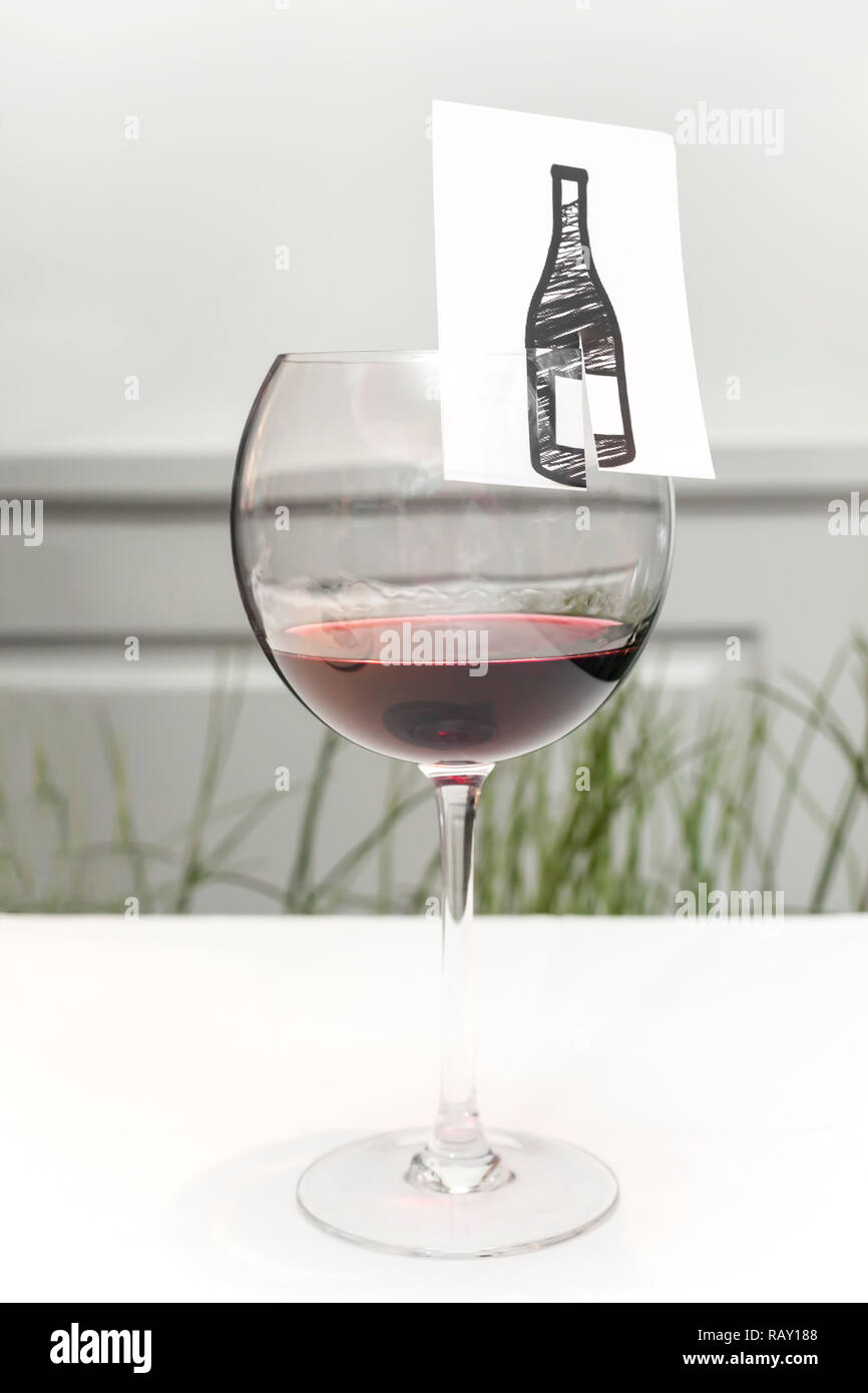 Red wine in a wine glass with a blank name tag on the table Stock Photo