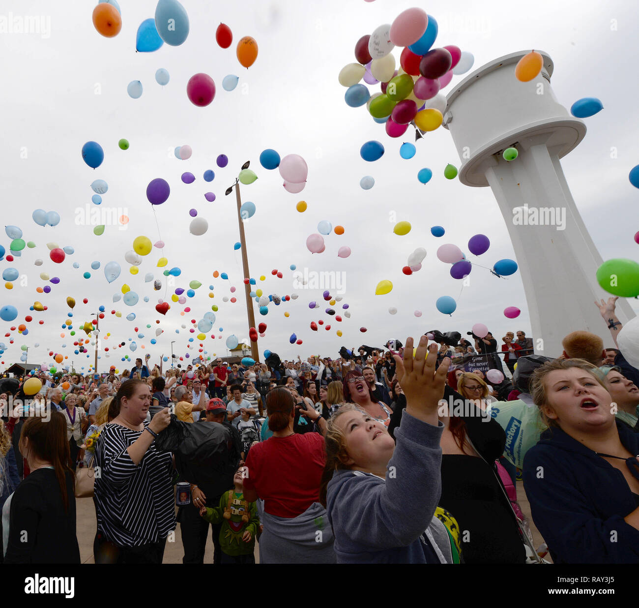 People gather at the mouth of The River Arun to pay tribute to the 11