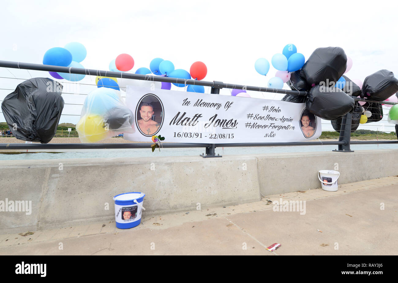 People gather at the mouth of The River Arun to pay tribute to the 11