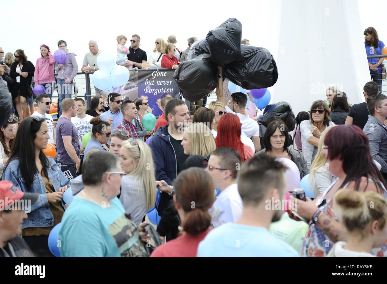 People gather at the mouth of The River Arun to pay tribute to the 11