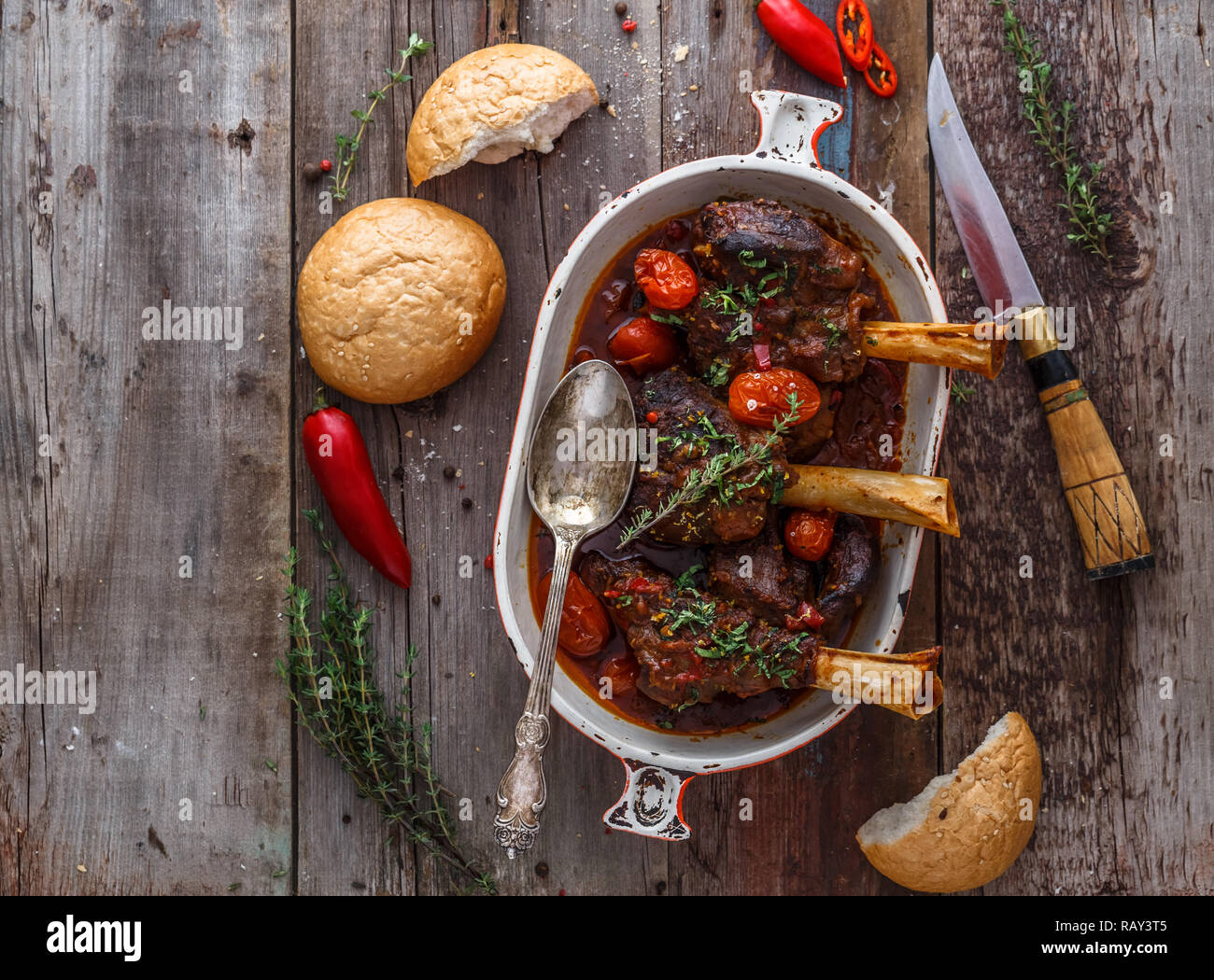Slow cooked lamb shanks with tomato and herds, copy space Stock Photo