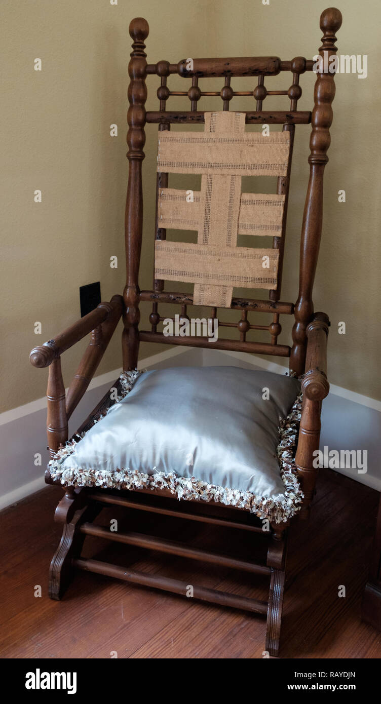 Decorative antique wooden chair with white satin pillow on wooden floor in Historic Texan Home, Chestnut Square Historic Village, McKinney, Texas. Stock Photo