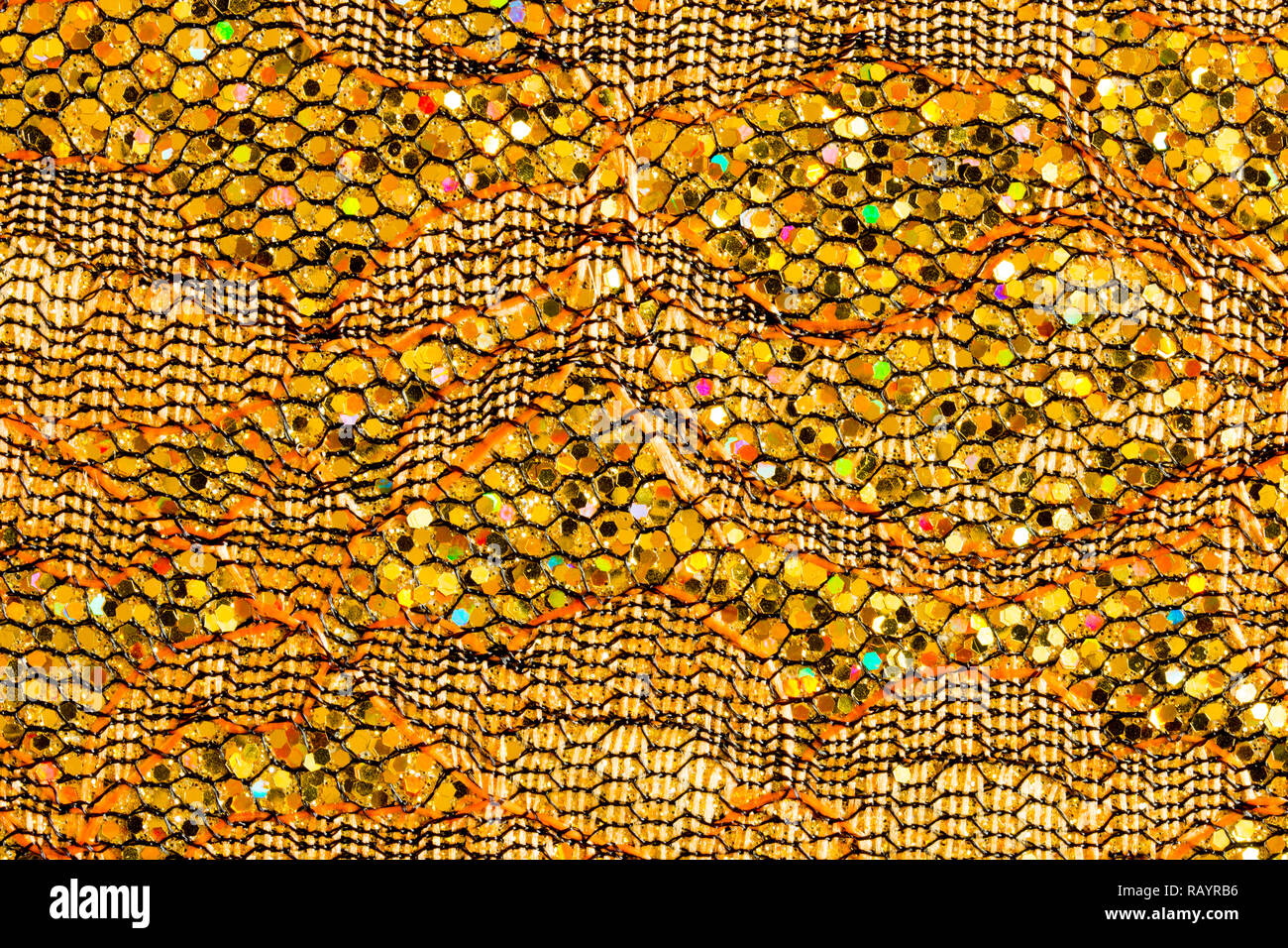 Abstract background of gold sequins on lace Stock Photo