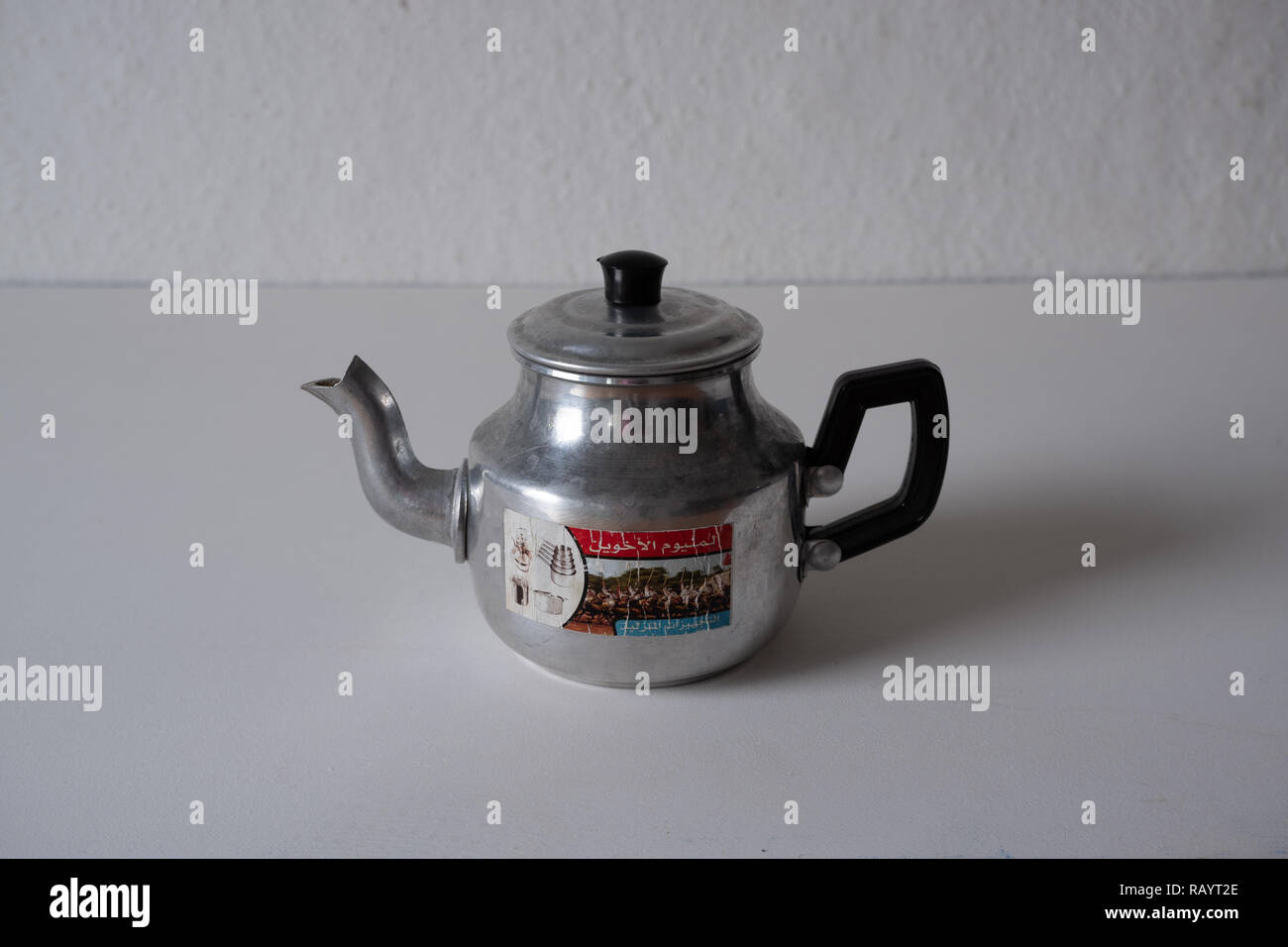 A Moroccan tea kettle made of aluminium against a white background