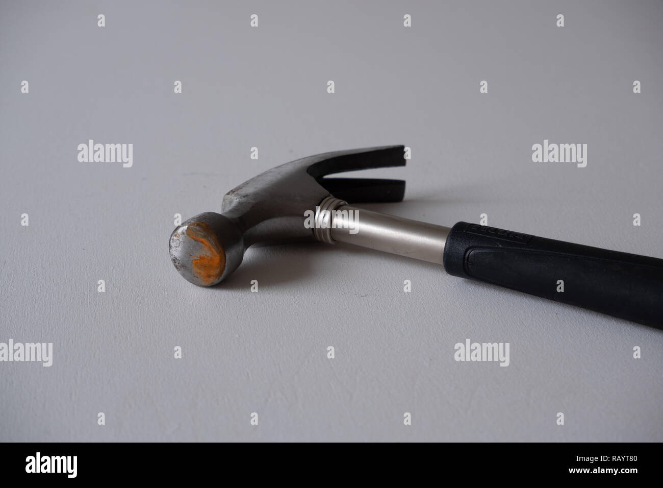 A rusty hammer with a black handle on a white background Stock Photo