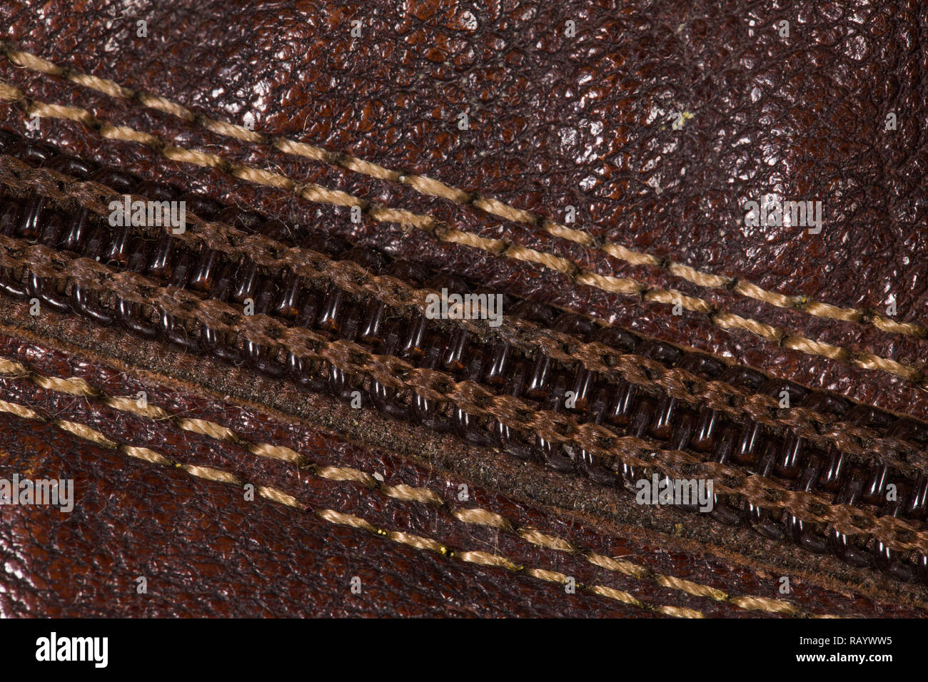 Closeup top view of leather brown closed zipper and brown natural leather material. Macro of details of footwear. Horizontal color photography. Stock Photo