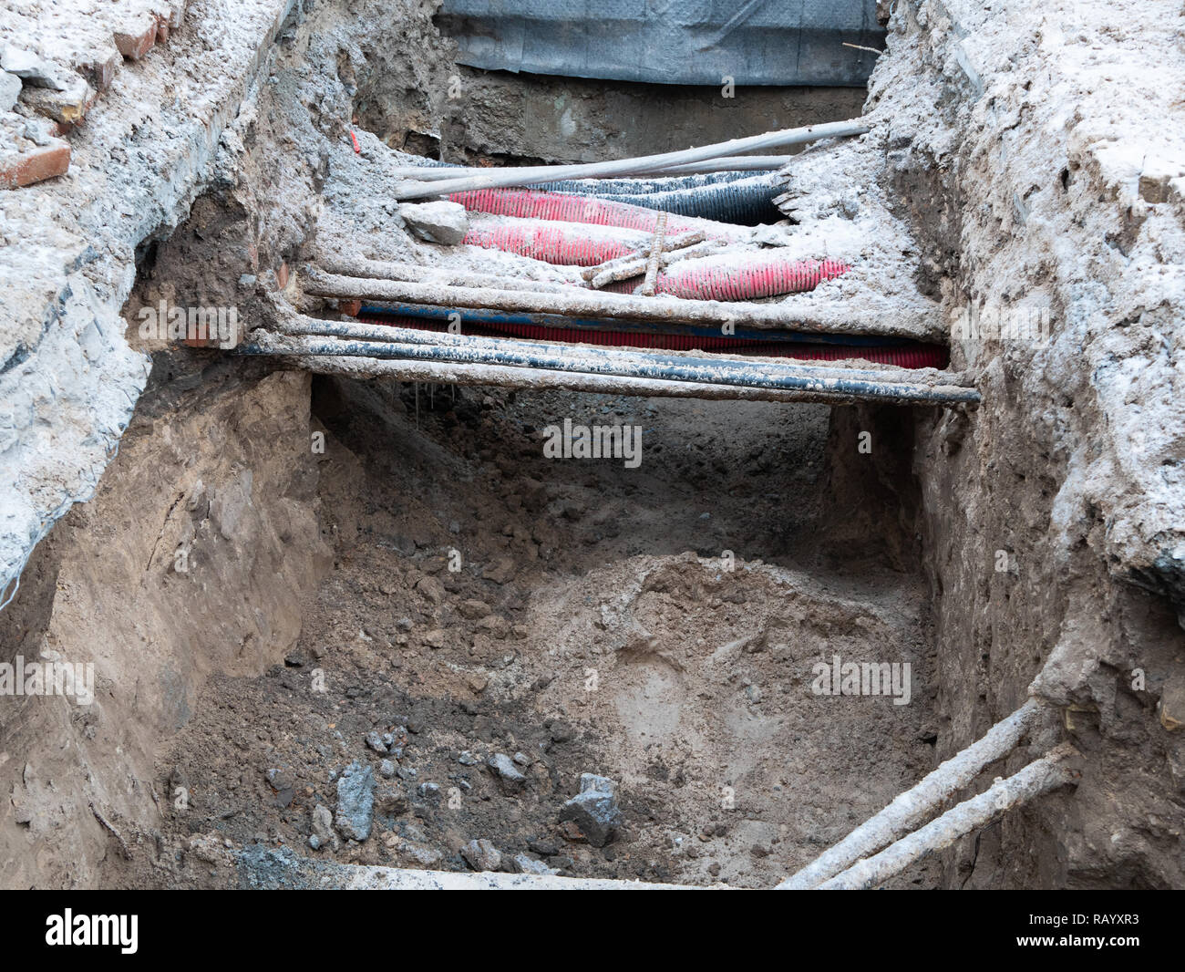 water pipes and electrical wires in ground pit trench ditch during