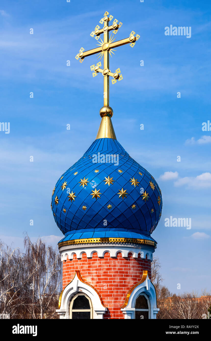 Dome of Russian orthodox church with golden cross against the blue sky ...