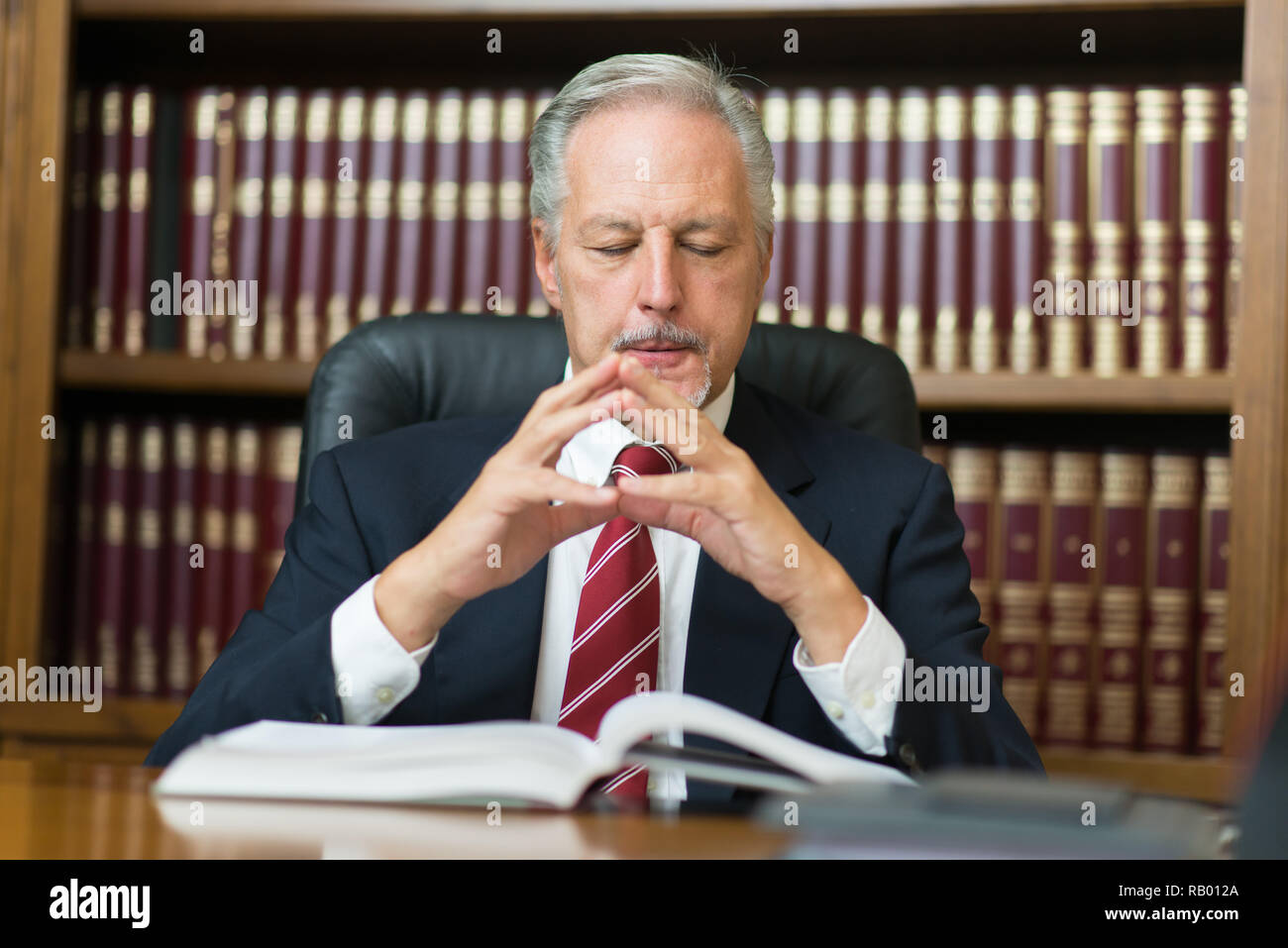 Senior lawyer businessman reading his notes in the home office