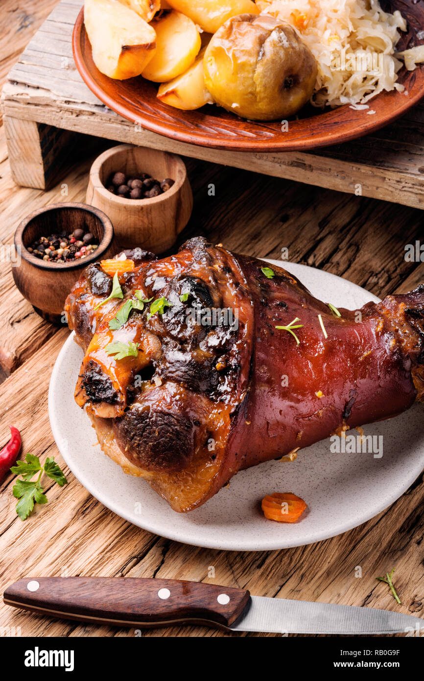 Pork knuckle on rustic table.Oktoberfest menu.Baked pork knuckle Stock