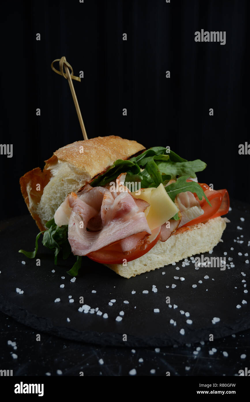 Luxury restaurant sandwitch with prochutto ham, green ruccola and cheese with tomatos. Stock Photo