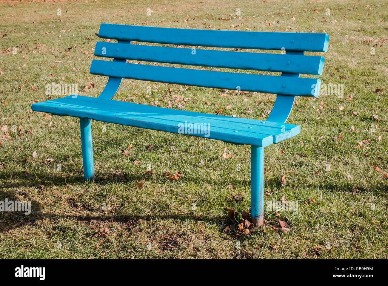 outdoor bench spray painted in light blue or aqua color Stock Photo