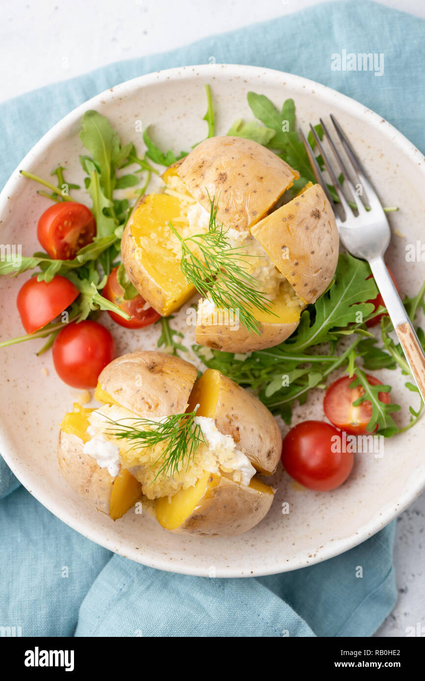 Baked potatoes stuffed with cheese and sour cream. Top view. Jacket