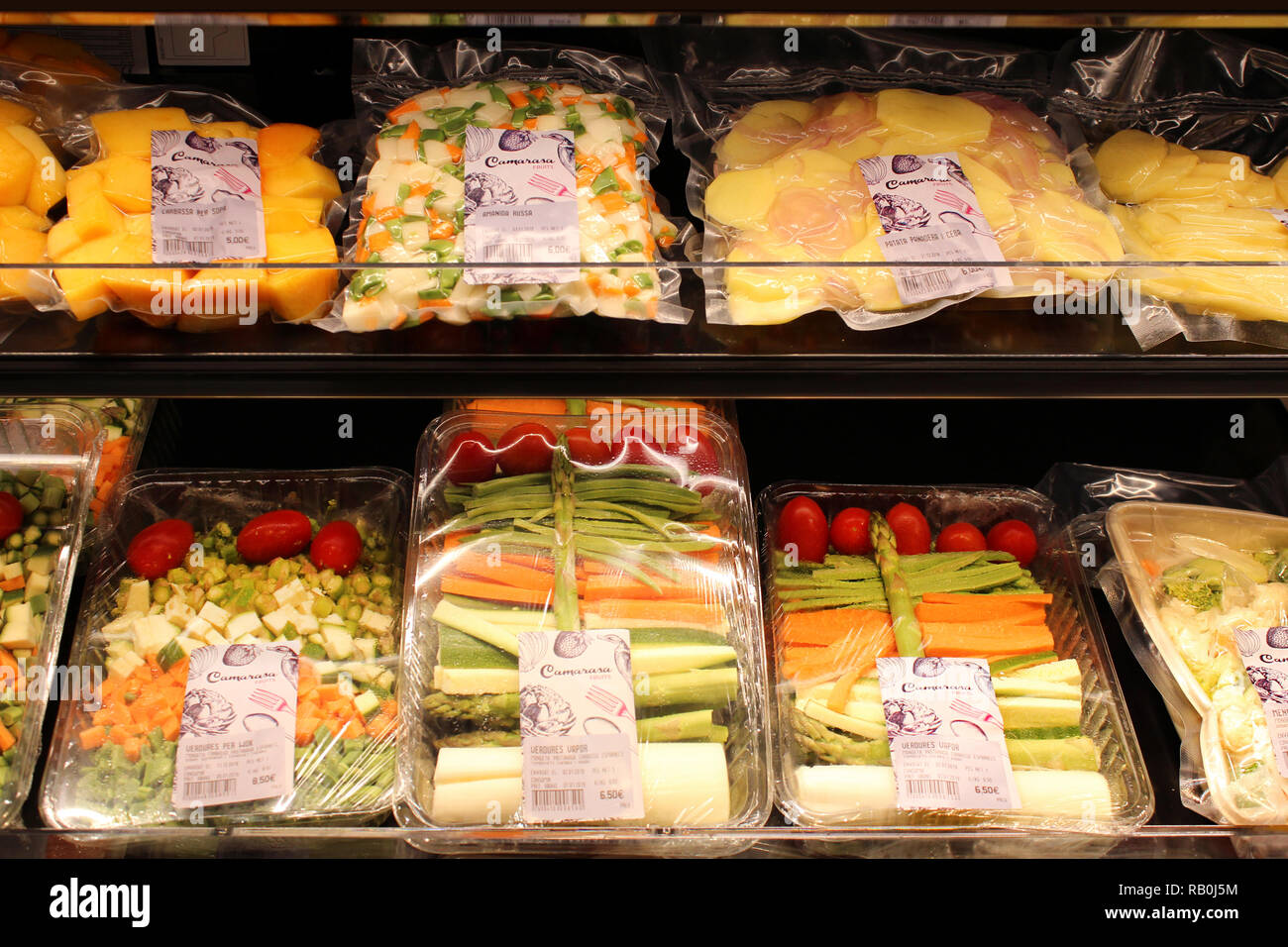 Vegetables on plastic trays displayed on supermarket Stock Photo
