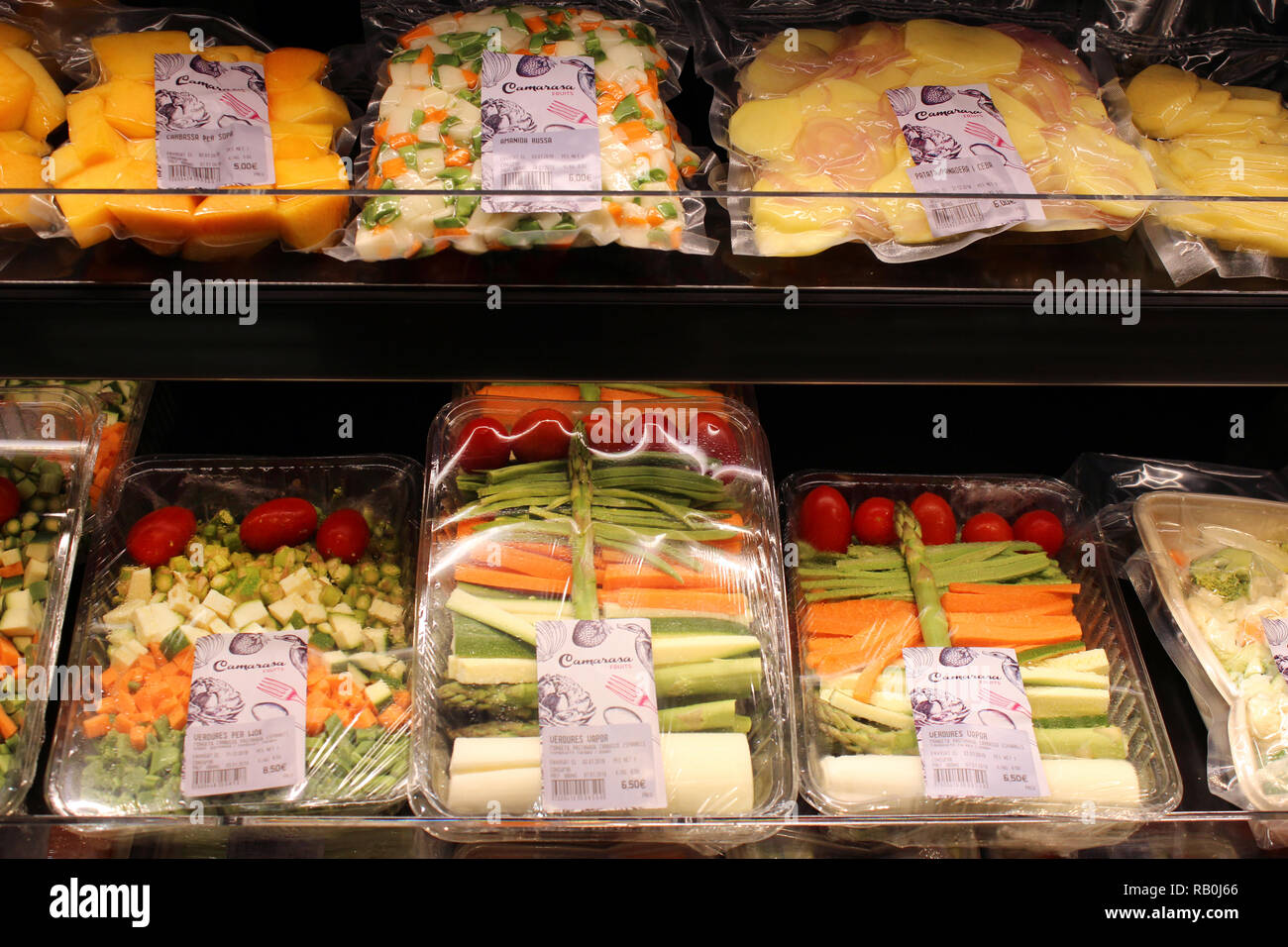 Vegetables on plastic trays displayed on supermarket Stock Photo