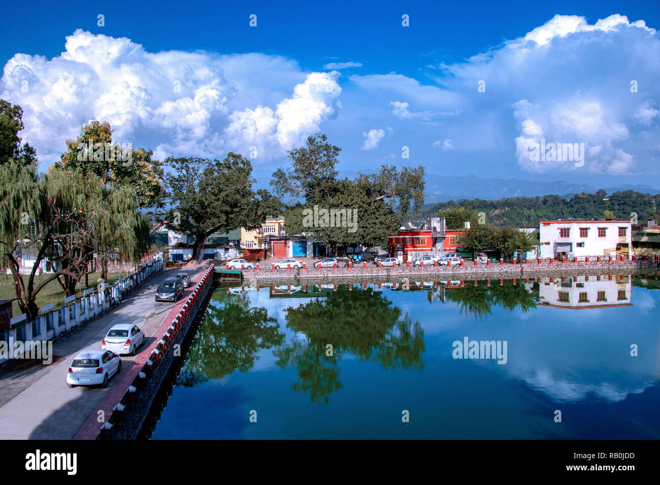 Landscape of pound, trees, mountains and beautiful white cloud and sky ...