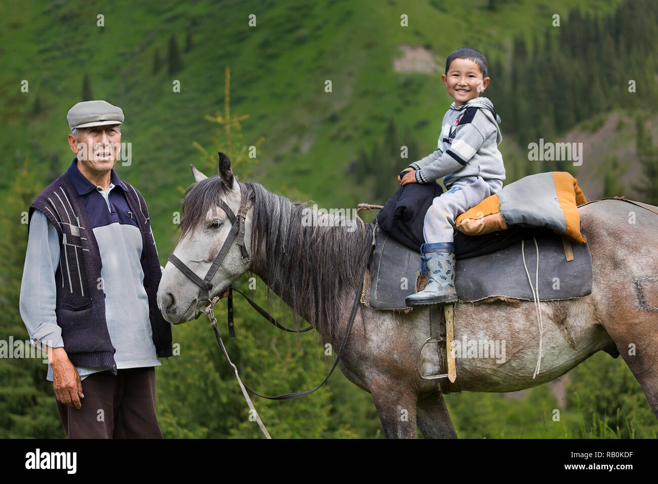 Kazakh man with his grandson on the horse, Kazakhstan. Stock Photo