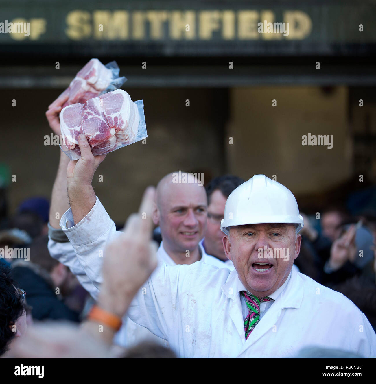 A butcher holds meat to sell during the annual Christmas Eve auction at Smithfield Market in the City of London on December 24, 2014. Stock Photo