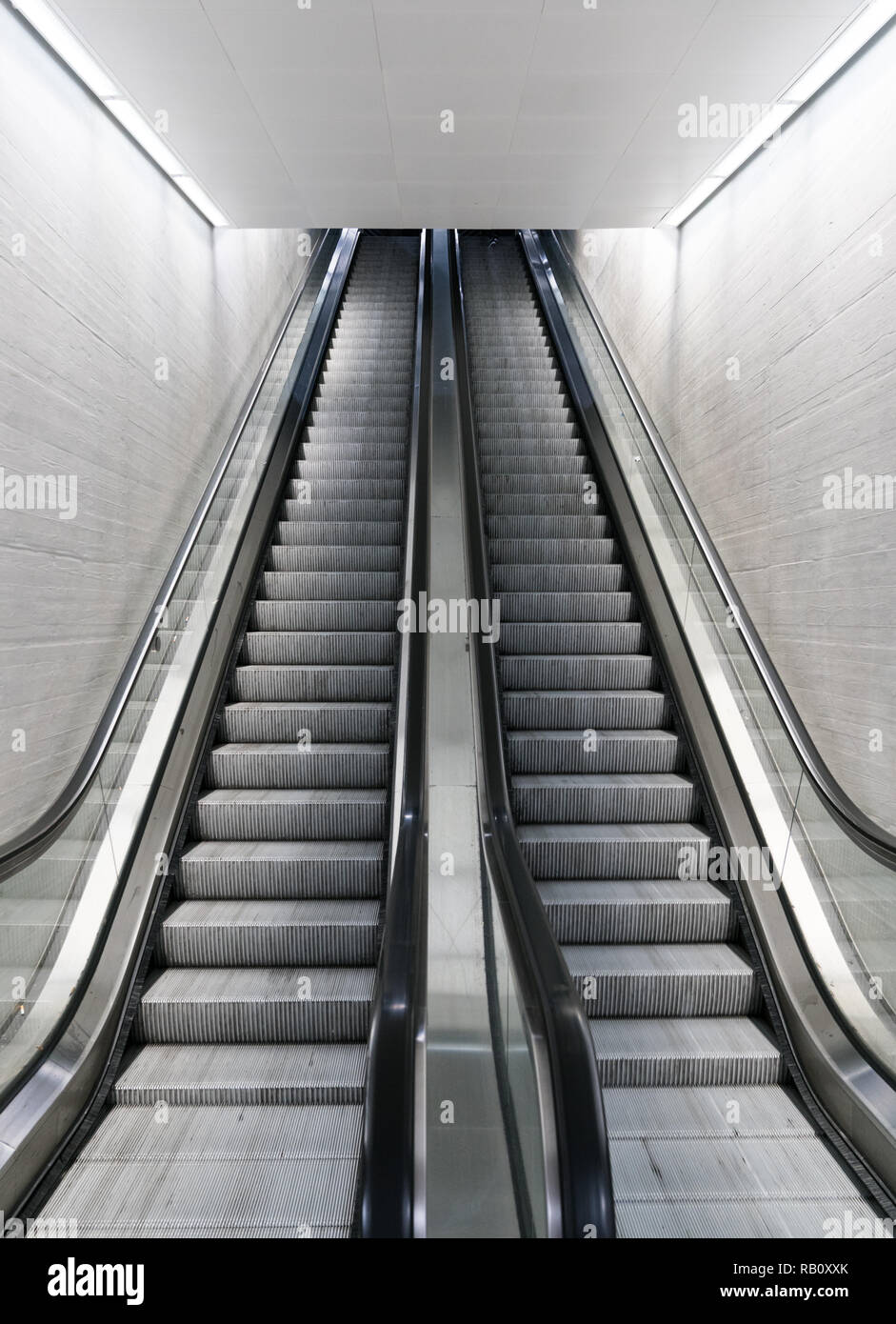 long escalator leading up in an empty train station Stock Photo