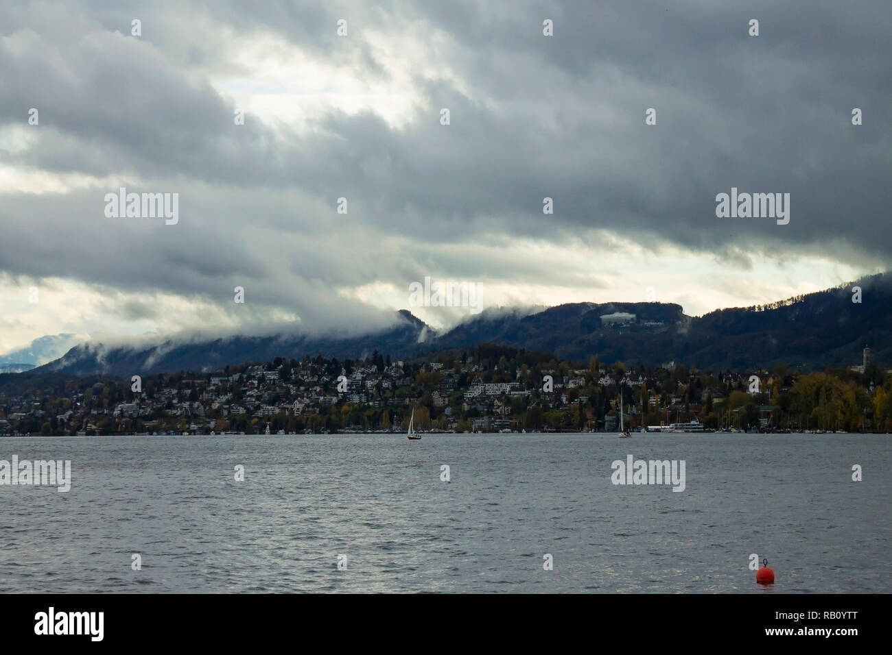 Beautiful cloudy skyscape with snow covered Alps mountains peaks on horizon. Lake Zurich landscape, central Switzerland. Vivid color. No people Stock Photo