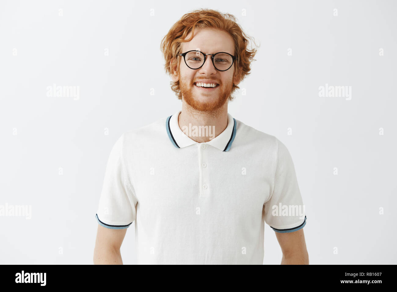 Attractive young and friendly redhead man with beard in black glasses and  polo shirt smiling joyfully at camera participating in interesting event  spending summer weekends with friends Stock Photo - Alamy