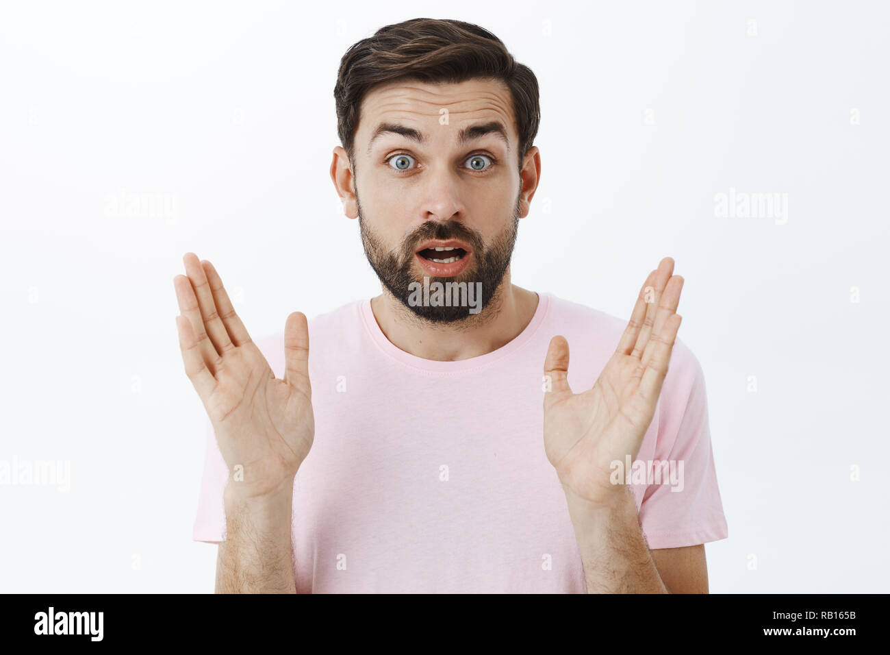 Amazed excited handsome male model with beard and dark short hairstyle