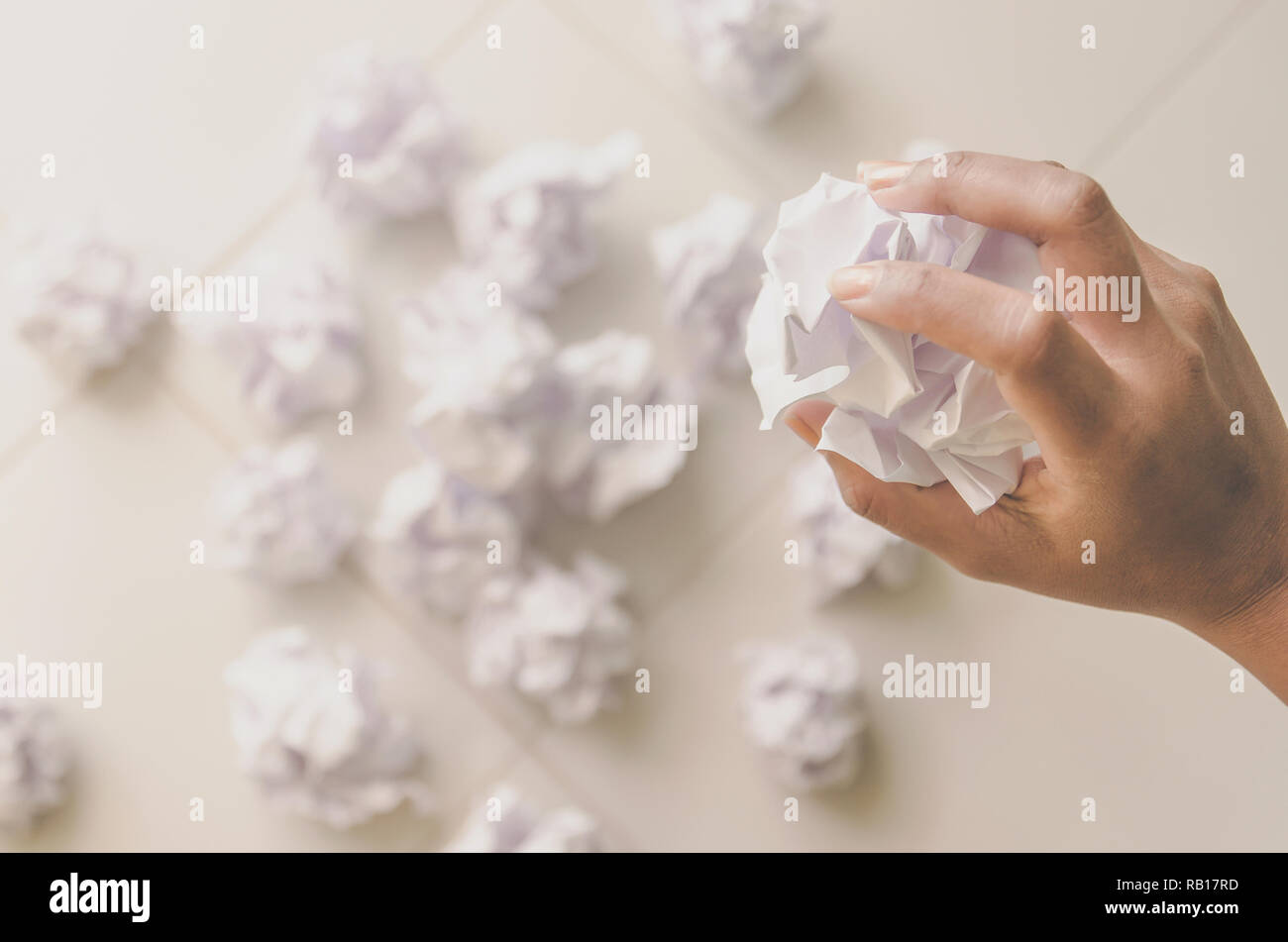 No idea and fail concept - Human hand holding crumpled paper or trash and white paper ball and waste on the floor, A hand are crumpling a paper, Recyc Stock Photo