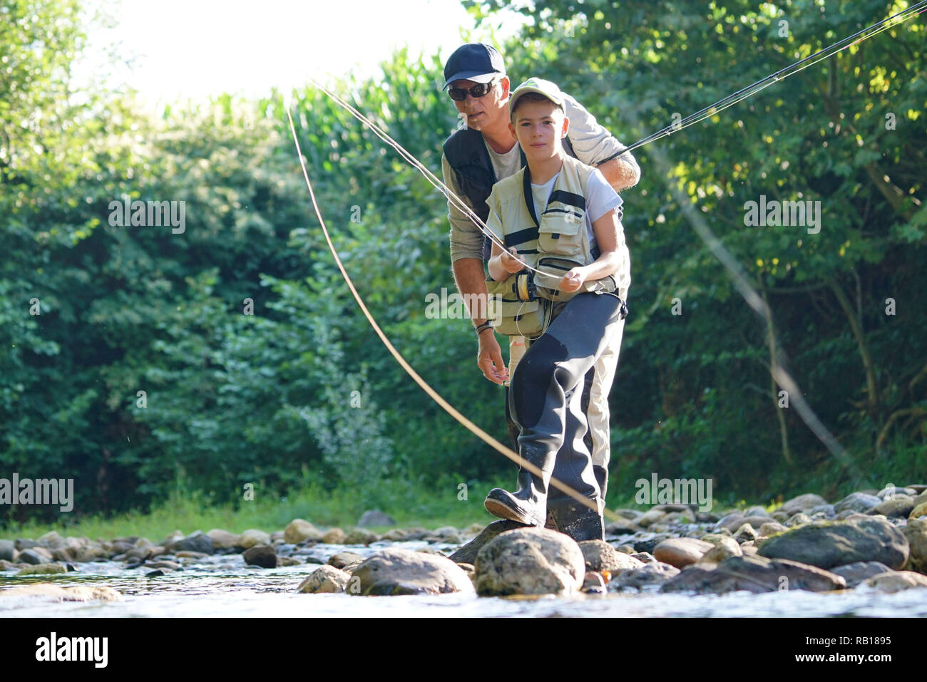 Father teaching son how to flyfish in river Stock Photo Alamy
