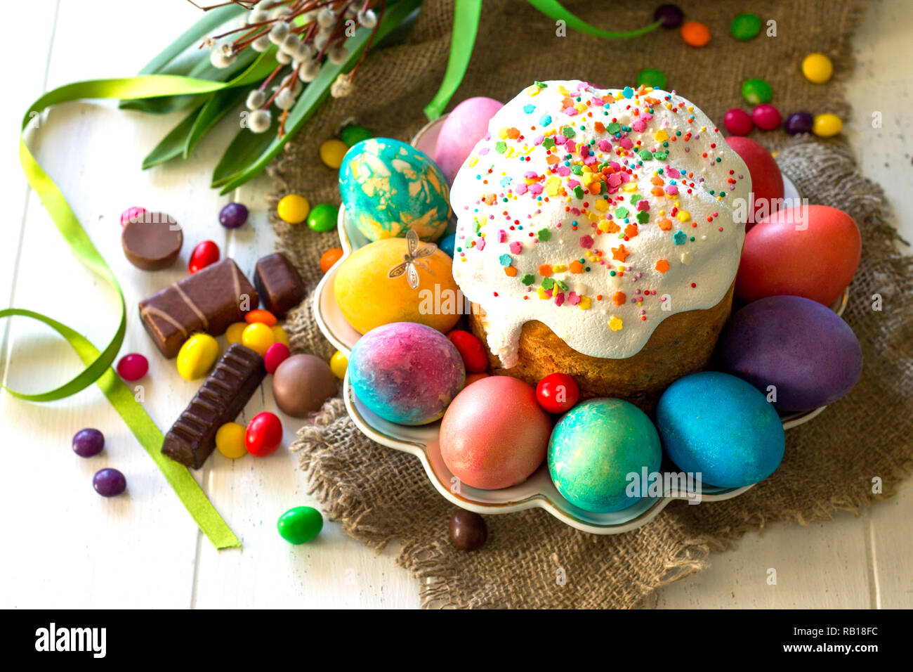 Festive composition in rustic style, Easter meal Breakfast. Easter cake and painted eggs on white wooden table. Stock Photo
