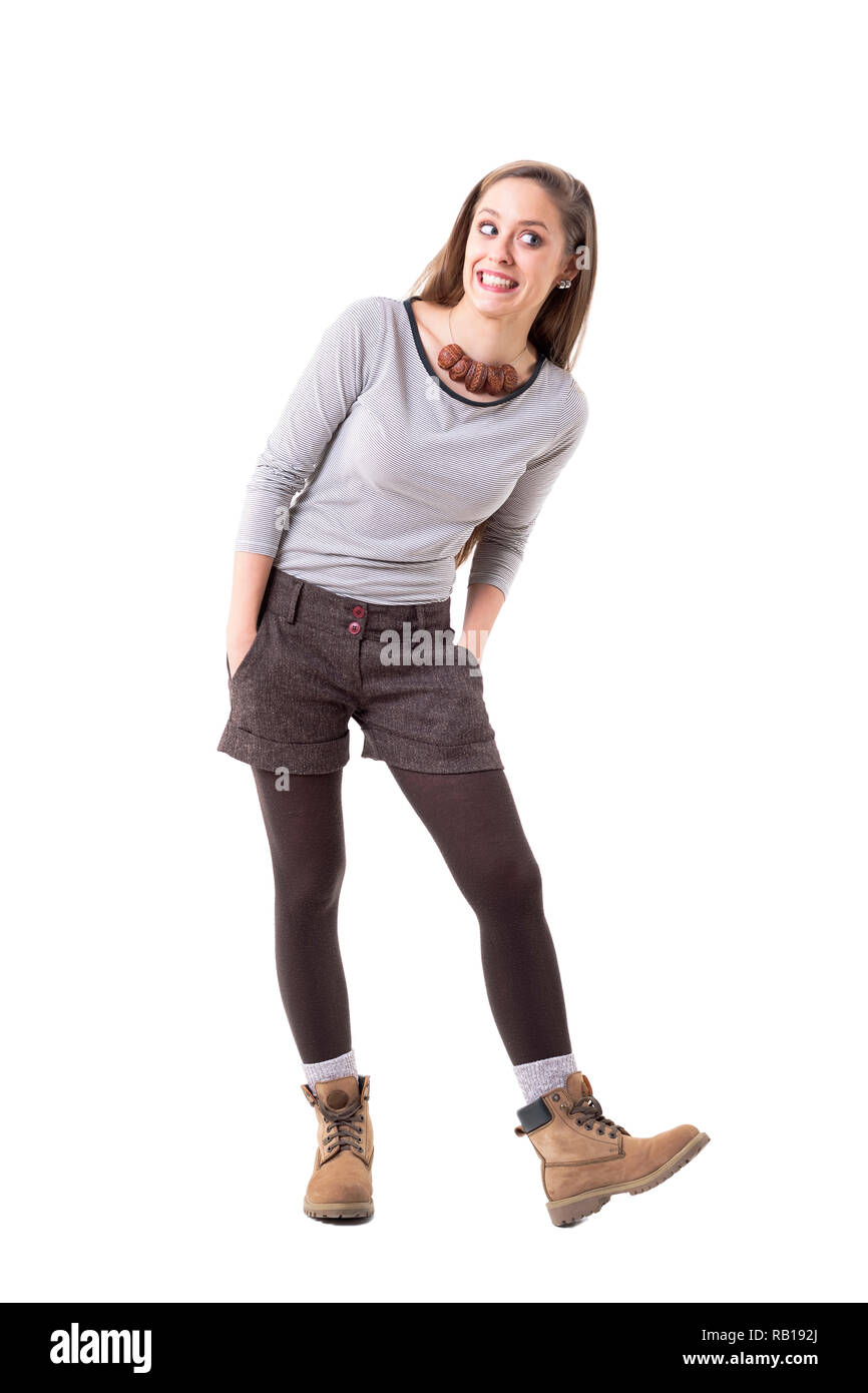 Cool funky cute hipster girl making funny face smiling and looking away. Full body isolated on white background. Stock Photo