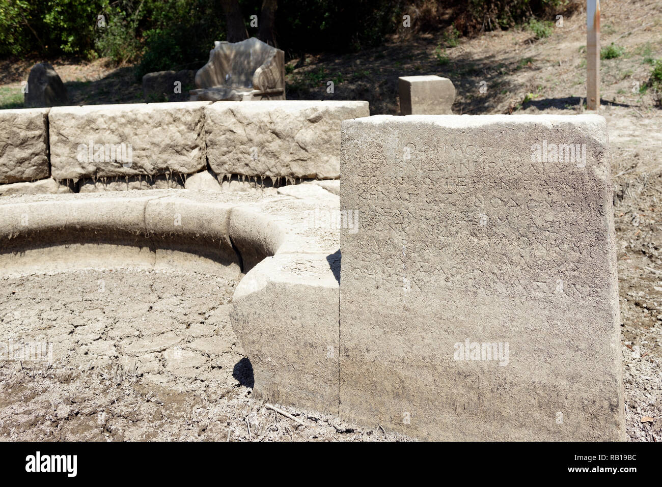 Ancient Greek inscriptions on a Exedra, a semicircular recess where visitors sat and conversed, ancient Greek sanctuary of Apollo of Claros, Turkey. Stock Photo