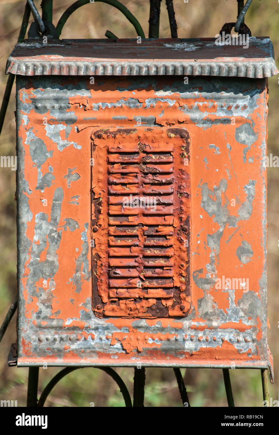 Old weathered grunge rural corroded metal post box on iron garden door closeup Stock Photo