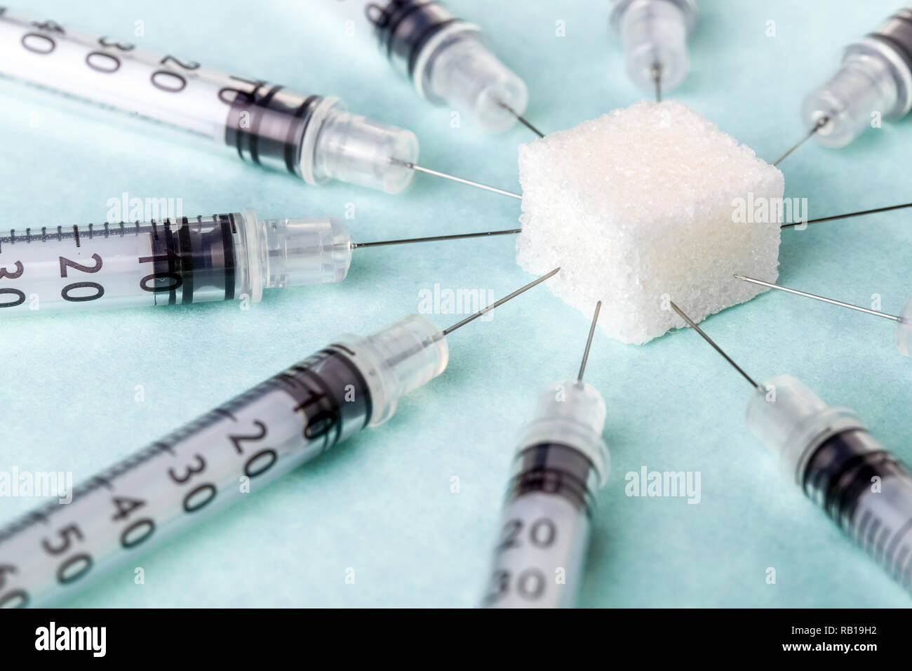 insulin syringes stuck in a sugar cube, diabetes treatment concept Stock Photo